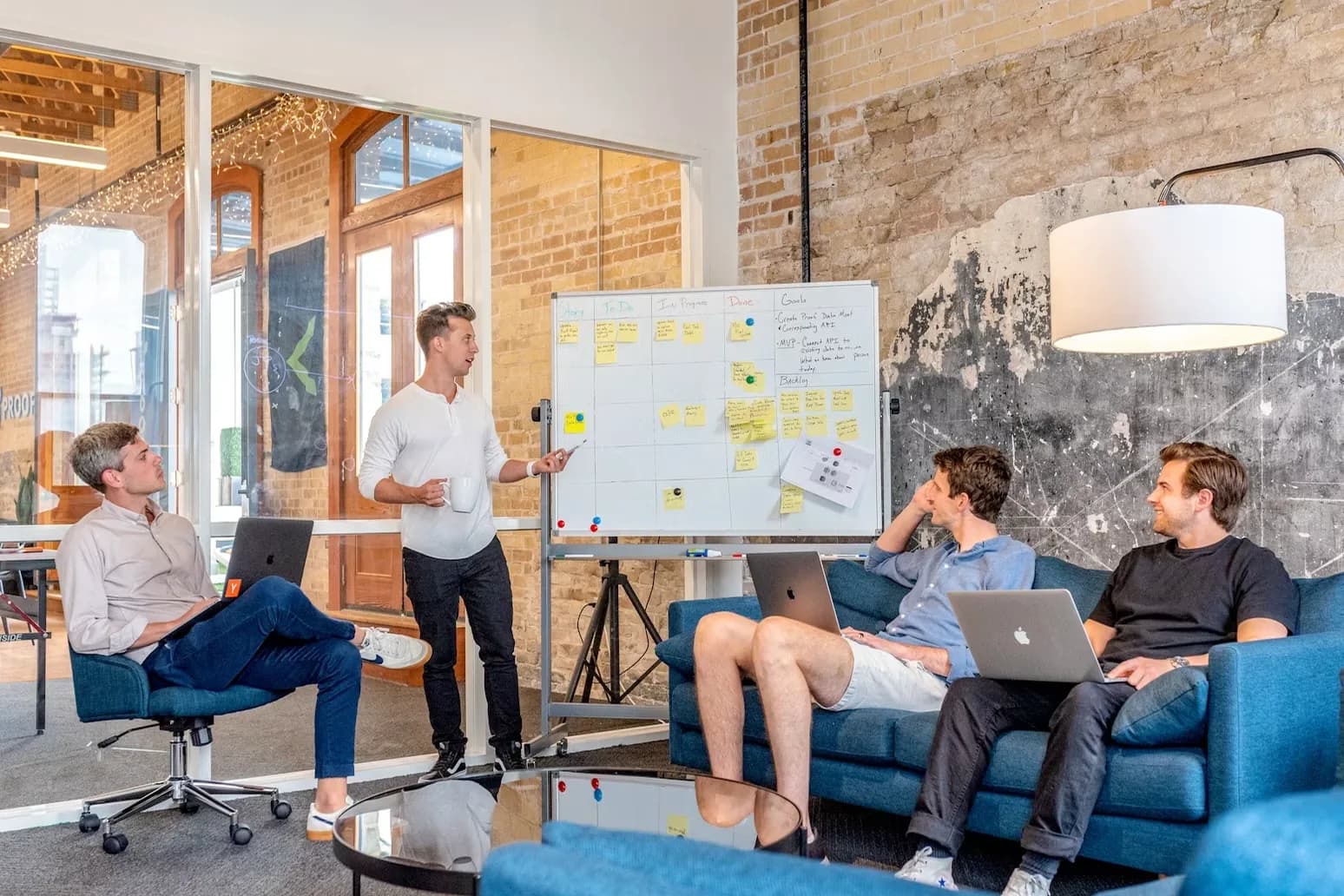 A marketing lead walks a team through a plan on a whiteboard